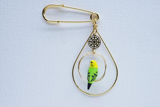 Brooch of a budgie (green) with one rider